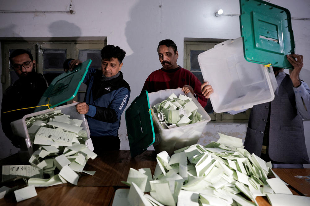 Polling staff empty a ballot box after polls closed at a polling station during the general election, in Lahore, Pakistan, February 8, 2024.