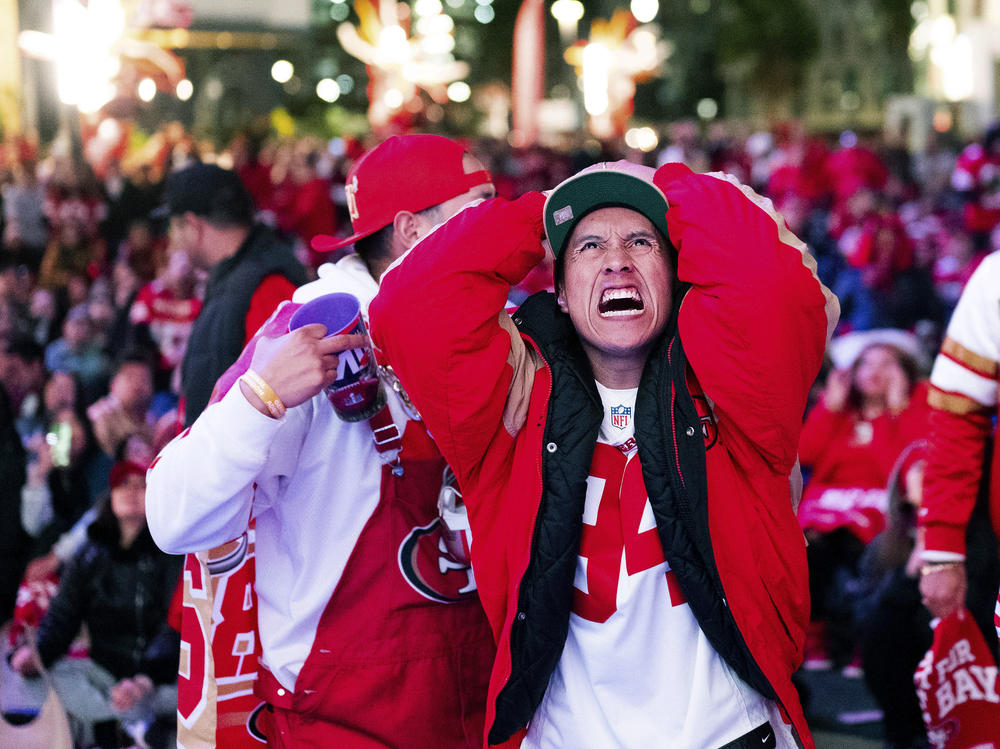 A San Francisco 49ers fan reacts while watching a telecast of NFL football's Super Bowl 58 on a screen outside the Chase Center in San Francisco on Sunday, Feb. 11, 2024.