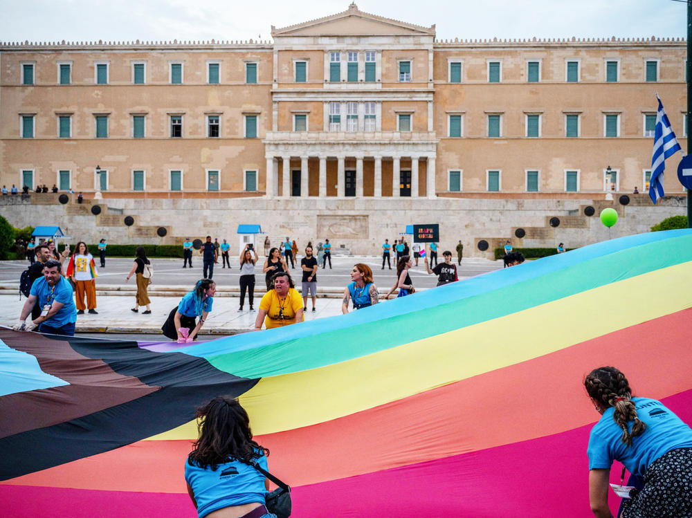 Participants hold a giant rainbow flag in front of the Greek parliament during the Athens Pride parade in Athens on June 10, 2023.