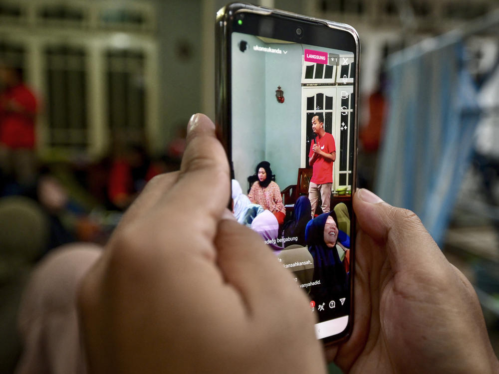 A man records a campaign video for social media to be used by Ukon Furkon Sukanda, a legislative candidate of the Indonesian Democratic Party of Struggle (PDI-P), in Tangerang, Banten province, Indonesia, Jan. 10.