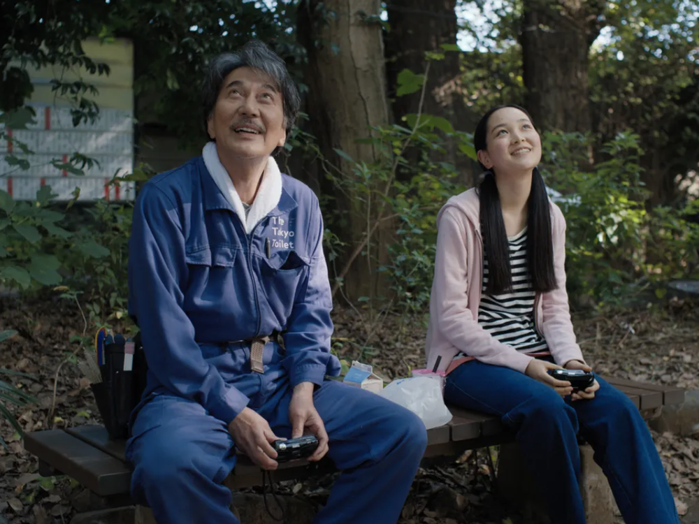 Hirayama (Kōji<em> </em>Yakusho) sits with his niece Niko (Arisa Nakano) in <em>Perfect Days.</em>