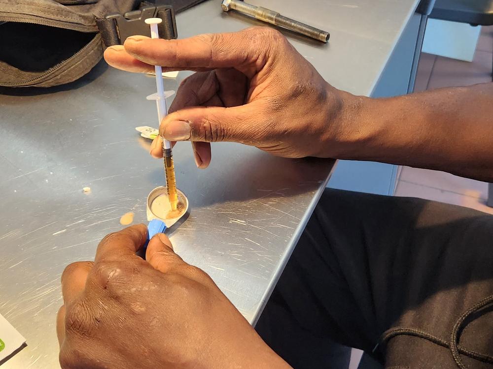 A person addicted to heroin prepares to inject at a consumption clinic in Lisbon, under the supervision of nurses.  People in Portugal are 45 times less likely to die from an overdose compared with people in the U.S.