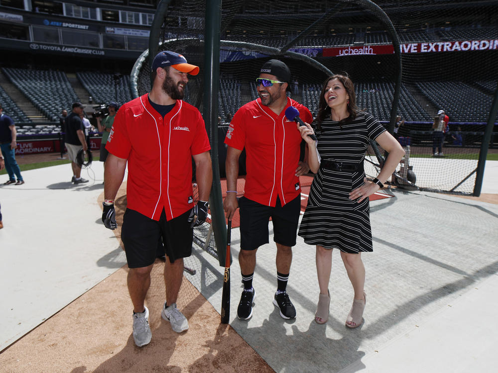 Colorado Rockies television announcer Jenny Cavnar, right, jokes with Vinny Castilla, center, special assistant to the Rockies general manager, and Denver Broncos fullback Andy Janovich after they took part in the UC Healthy Swings Charity Home Run Derby Tuesday, June 11, 2019, in Coors Field in Denver.