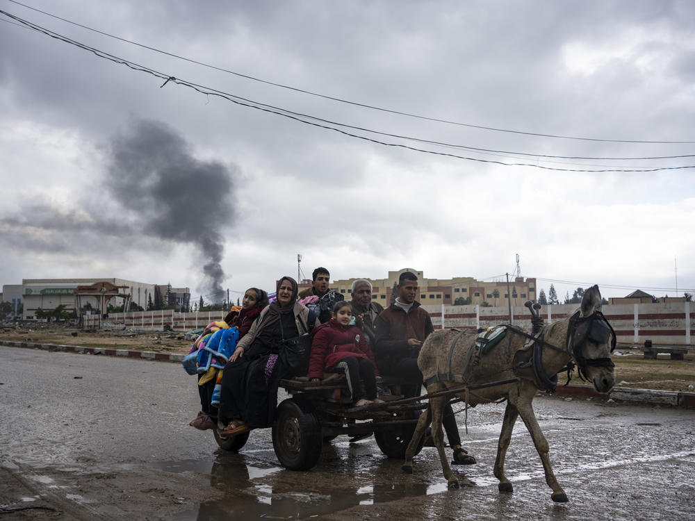 Palestinians flee from the city of Khan Younis in southern Gaza after an Israeli ground and air offensive on Monday, Jan. 29.