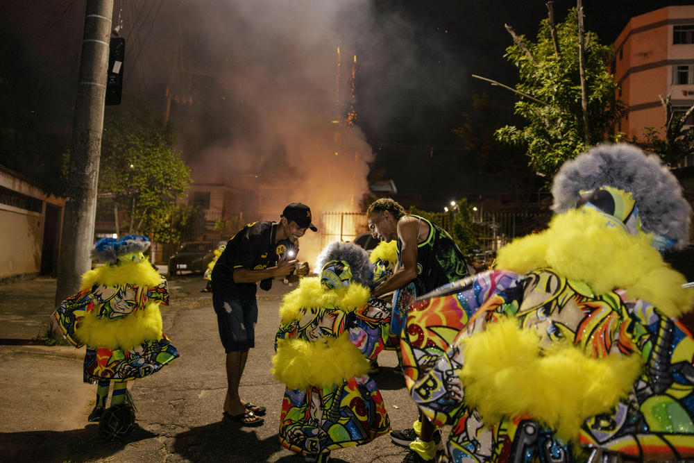 Older members of the bate-bola crew Brilho help the children of the crew make their first Carnival outing in Rio de Janeiro's Anchieta neighborhood on Feb. 9.