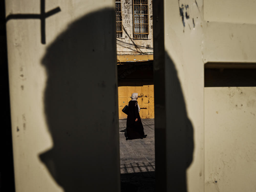 A woman walks by on the Palestinian-designated side as seen from the Israeli settlement enclave side of the Old City of Hebron on Nov. 5.