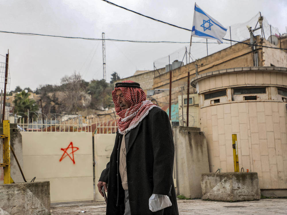 A Palestinian man walks past an Israeli checkpoint in Hebron on Dec. 24.
