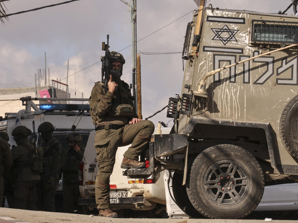 A member of the Israeli security forces stands guard. An attack against troops was reported near the West Bank city of Hebron on Feb. 1. Many settlers have joined the military's regional defense units since the Oct. 7 attack on Israel by Hamas-backed militants.
