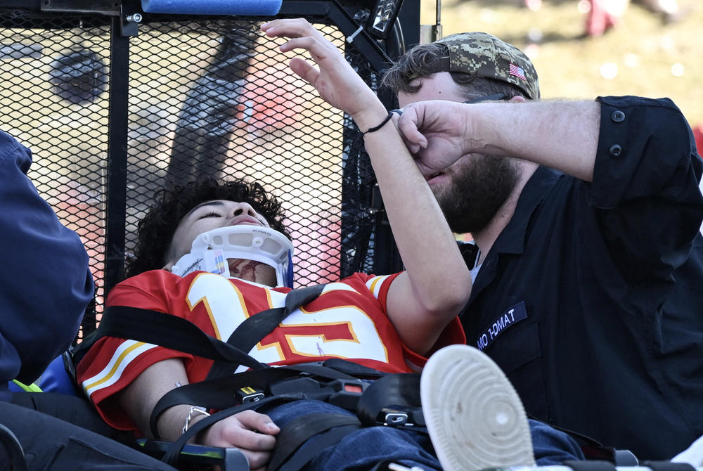 An injured person is aided near the Chiefs' Super Bowl victory parade.