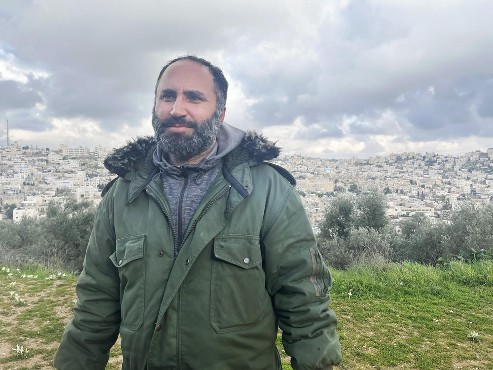 Issa Amro stands outside his home in Hebron. Amro says that since Oct. 7, settlers in and out of uniform have been harassing Palestinian civilians.