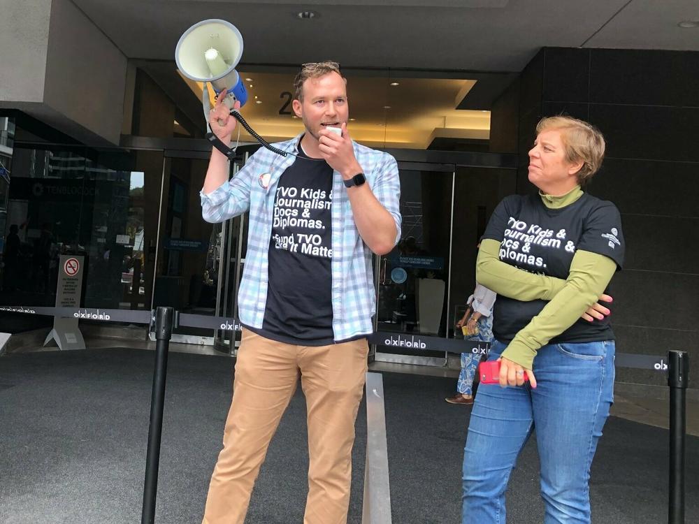 NewsGuild President Jon Schleuss speaks into a bullhorn at a rally of TVO employees in August 2023.