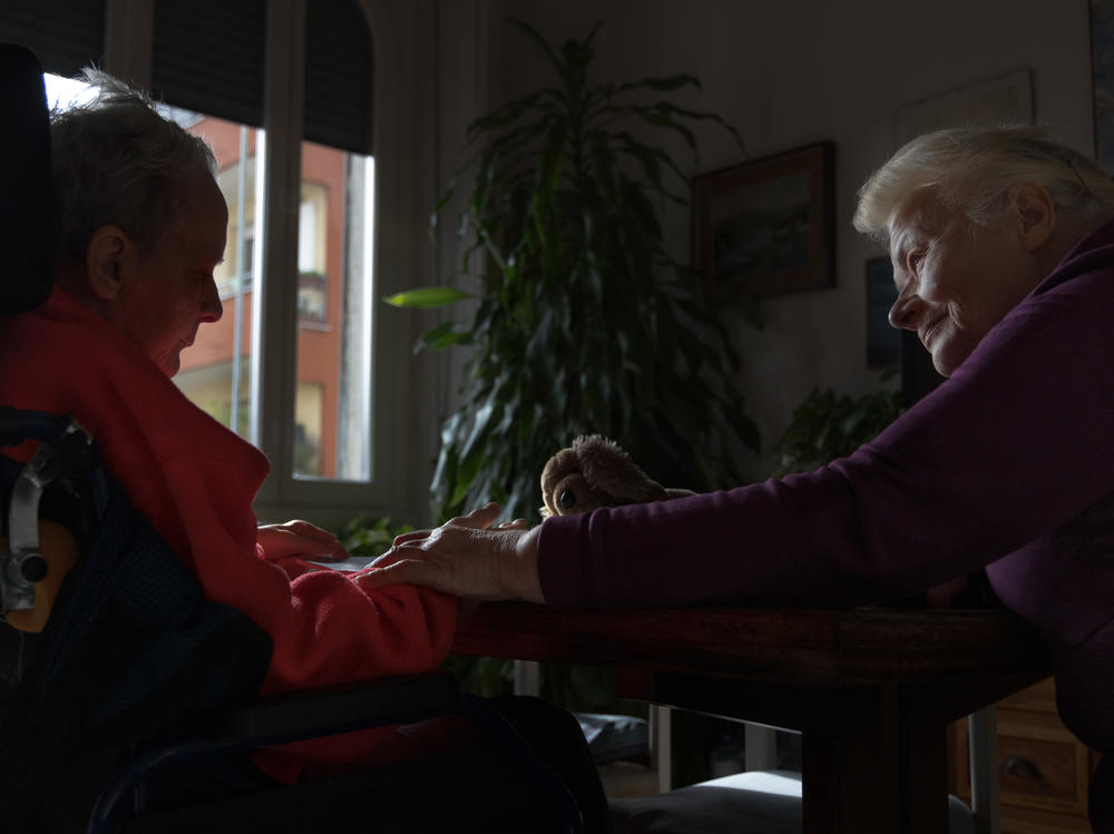 Caregiver Vira Zhmurko (right) holds Anna's hand in Milan in November 2023. Vira had come to Italy a few days before Feb. 24, 2022, to substitute for a friend who had to return to Ukraine. However, after the war broke out, Vira found herself stuck as her city was being bombed by Russia.