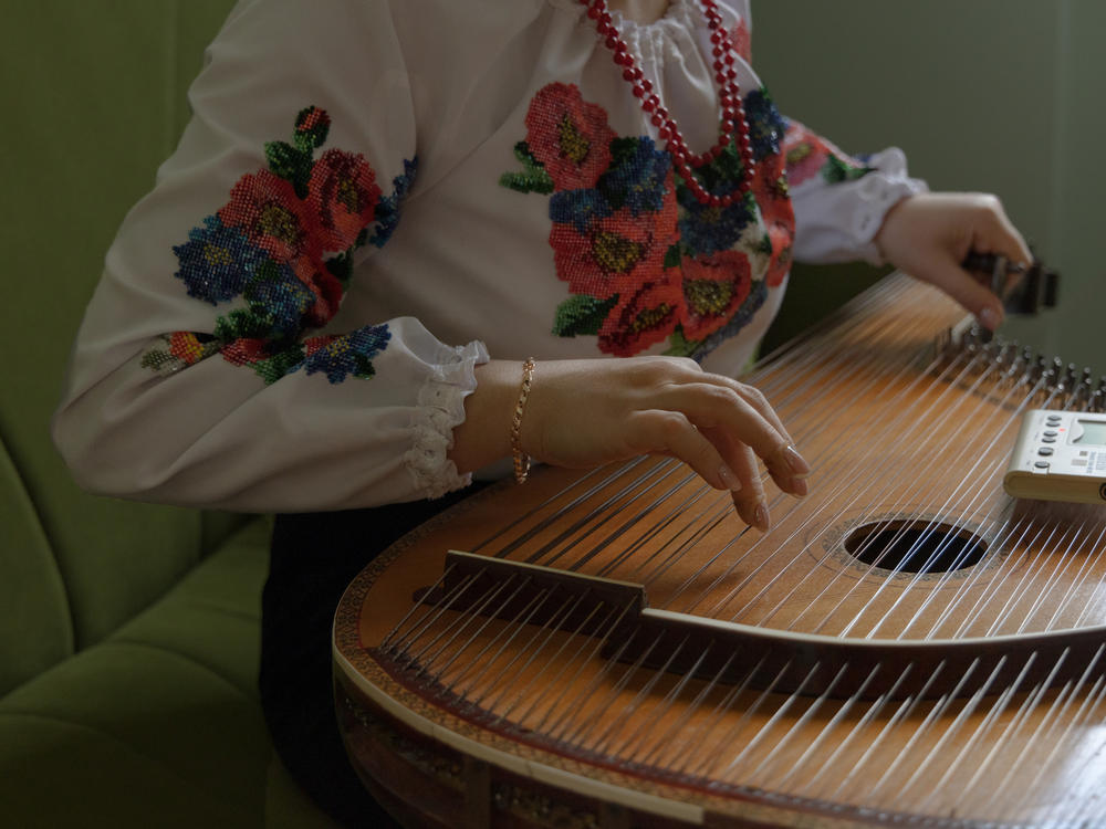 Olena Melnyk tunes the bandura, Ukraine's national instrument, in Ravenna, Italy, in January 2023. Olena works as a caregiver, but she studied to be a professional bandora musician. Today, she uses the instrument to bring people closer to her culture.