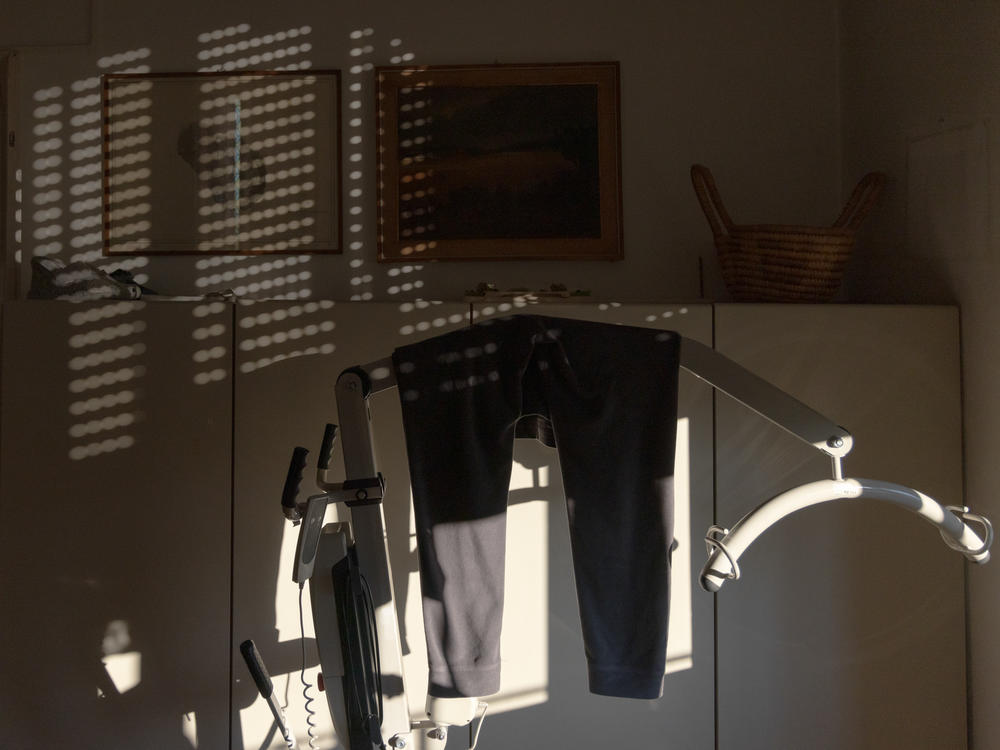 Clothing hangs on a mechanical lifter in Anna's home in Milan in December 2022.