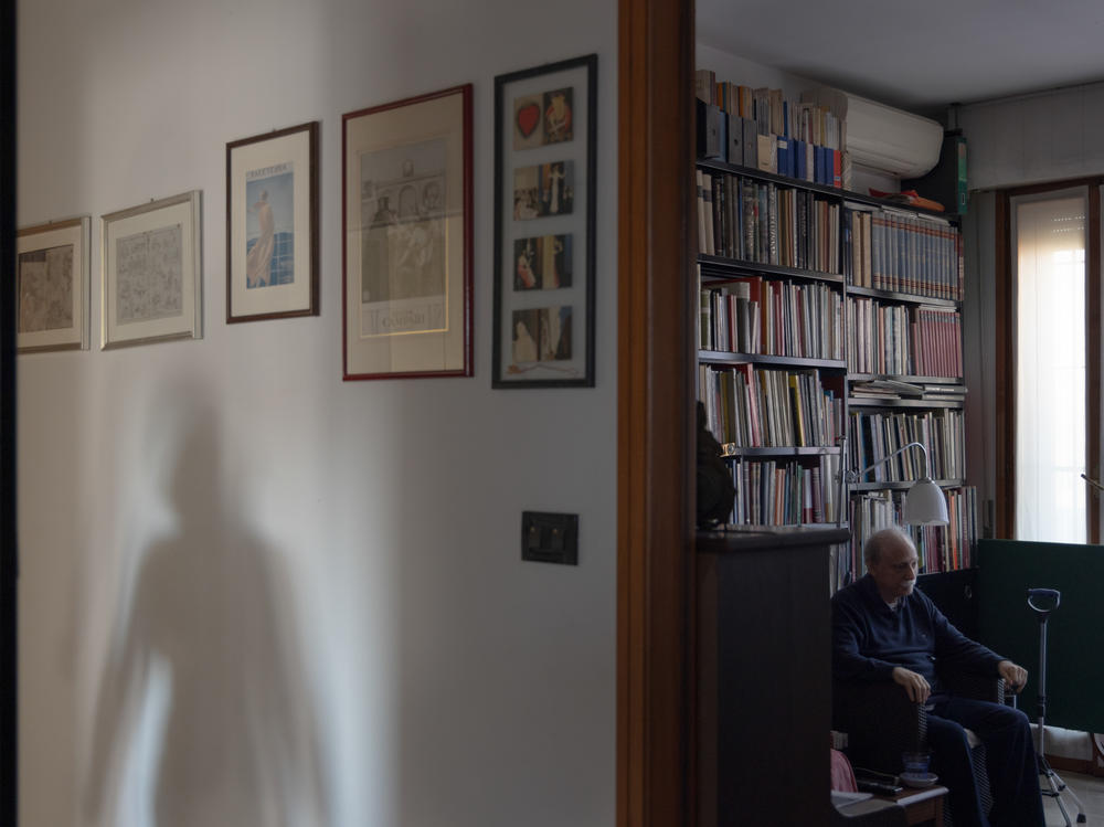 Caregiver Maria Oleksiivna Fedoryshyn's shadow appears as she goes to the kitchen to prepare the lunch for Tommaso, the man she cares for, in Bologna, Italy, in December 2022. Maria was vital in supporting Tommaso and his family when he returned from the hospital after he had a stroke, helping him recover and supporting his wife and son. Maria has lived in Italy for 20 years.