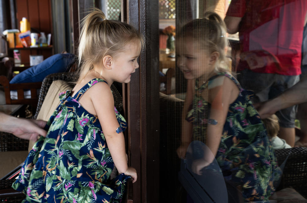 Ayla Souza plays on the wraparound porch of her family's temporary home. Her parents have tried to create some stability here after their life in Lahaina was completely disrupted by the wildfires.