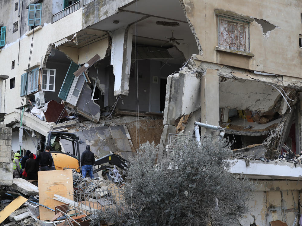 Civil defence and rescue workers remove rubbles from a building that was attacked Wednesday by an Israeli airstrike, in Nabatiyeh town, south Lebanon.