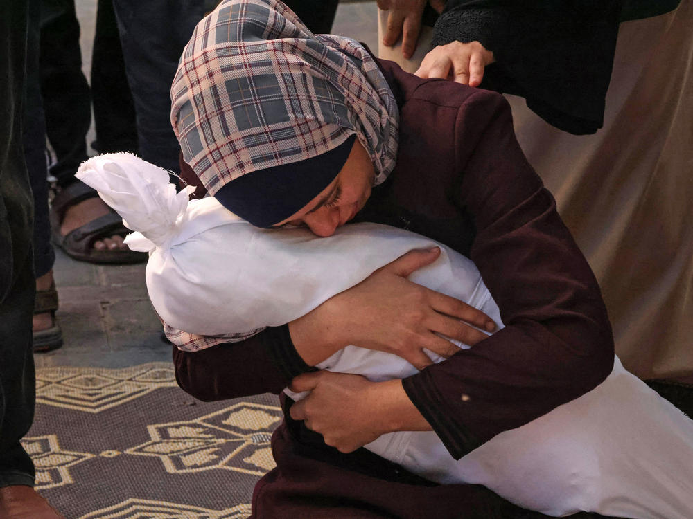 Palestinian Samia al-Atrash holds her niece Masa, who was killed along with her family in an Israeli bombardment in Rafah, Gaza Strip, on Oct. 21.