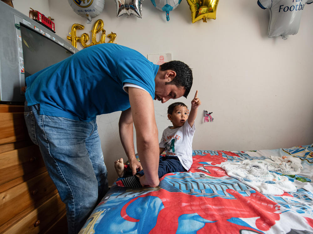 Ferley Sáenz, a 40-year-old coordinator of Bogotá's transportation system, dresses his son Jeronimo for the day. Sáenz admits that his wife assumes most of the child care and household chores. For years, he considered this the norm, spending most of his days at work or with friends. Now he's trying to step up.