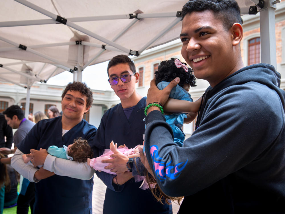 At a one-day workshop run by the Care School for Men in Bogotá, Colombia, male medical students at Sanitas University learn how to cradle a baby. This class of participants consists of medical students, but the usual enrollees are dads of all types.
