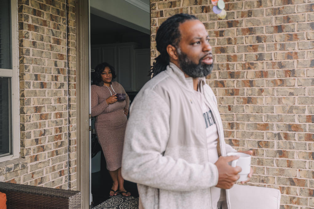 On the left, Iris Garcia watches her husband, Edmund Garcia, listens to a phone call from the Department of Veterans Affairs through his earpiece concerning his financial situation about his home.