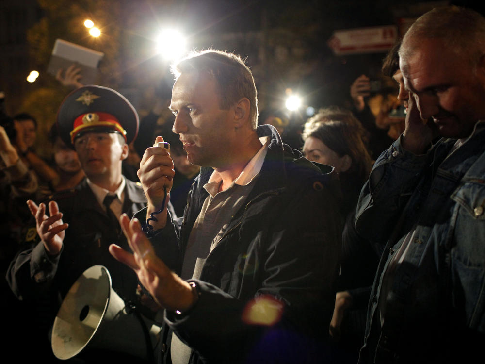 May 8, 2012: Alexei Navalny, a prominent anti-corruption whistle blower and blogger, center, speaks to protesters gathered across the street from the presidential administrations building as a police officer tries to stop him in downtown Moscow.