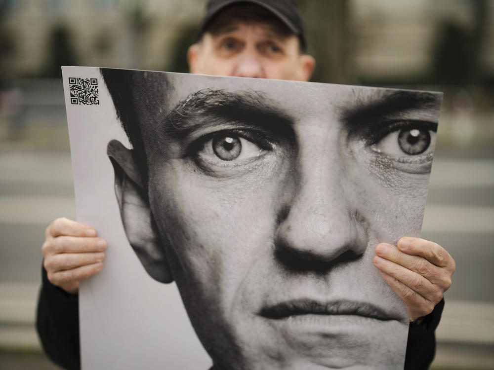 A man holds a poster with a portrait of opposition leader Alexei Navalny during a protest in front of the Russian Embassy in Berlin on Friday. Navalny, who crusaded against official corruption and staged massive anti-Kremlin protests as President Vladimir Putin's fiercest foe, died Friday in the Arctic penal colony, Russia's prison agency said.