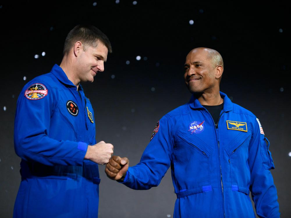 Astronauts Victor Glover (right) and Jeremy Hansen react at a news conference in Houston, Texas, on April 3, 2023, after the announcement that they have been selected for the Artemis II mission to venture around the moon.