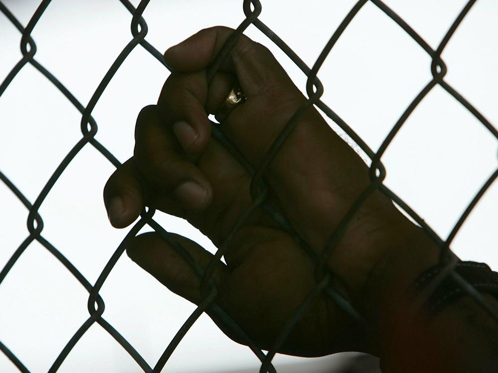 An inmate holds onto a fence during the Angola Prison Rodeo. The maximum security prison in Louisiana holds 5,000 men, the majority of them serving life sentences.