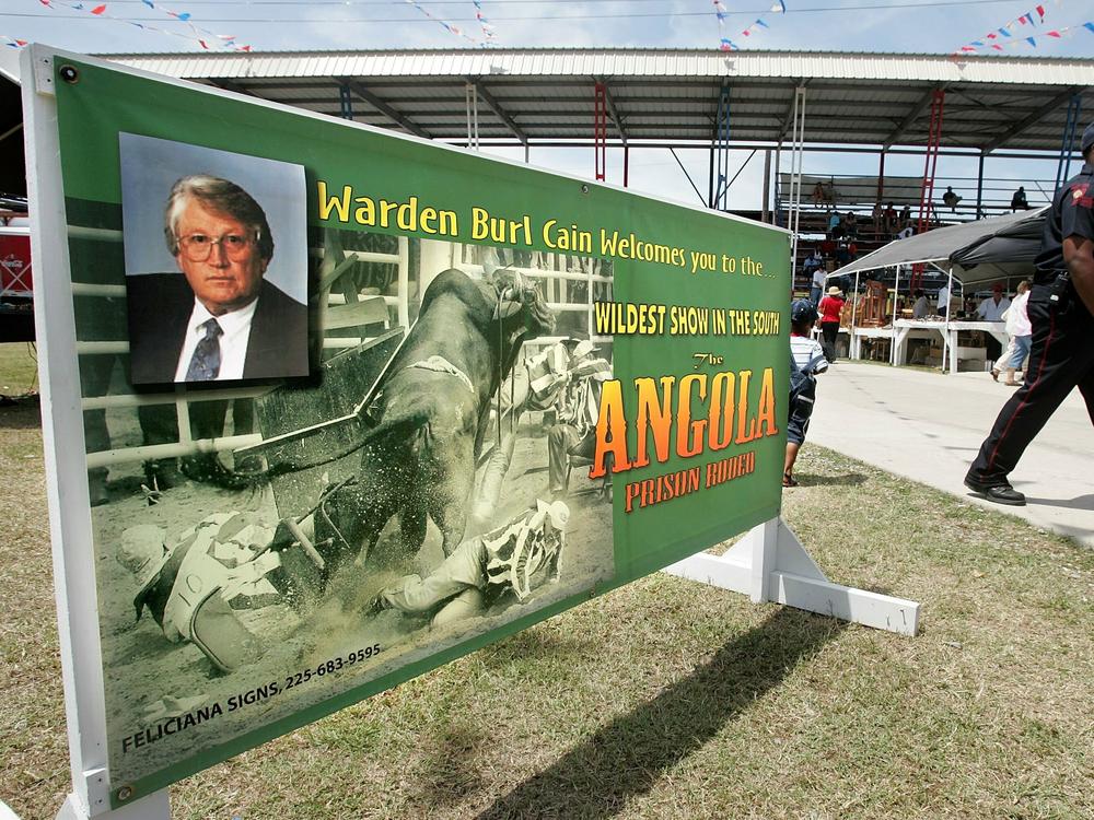 A banner advertising the Angola Prison Rodeo pictures warden Burl Cain, who started the penitentiary's hospice program.