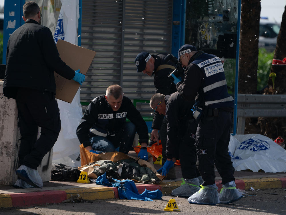 Israeli police investigate the site of a shooting attack at the Masmiya-Re'em junction in southern Israel on Friday, Feb. 16.