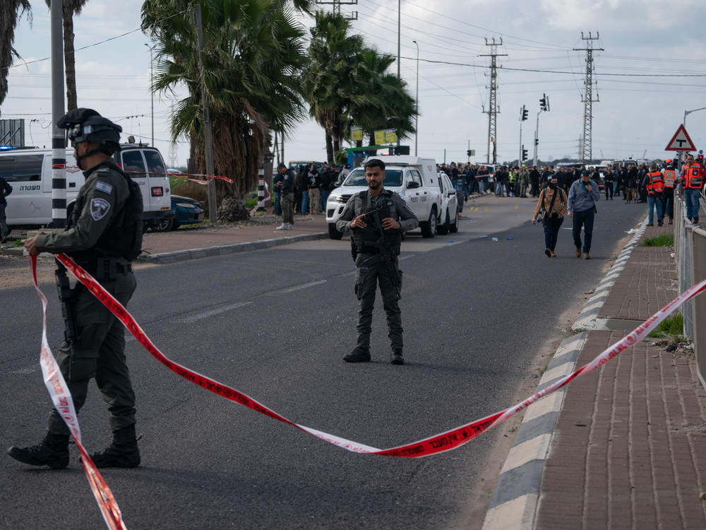 Israeli police investigate the site of a shooting attack at the Masmiya-Re'em junction in southern Israel on Friday, Feb. 16.