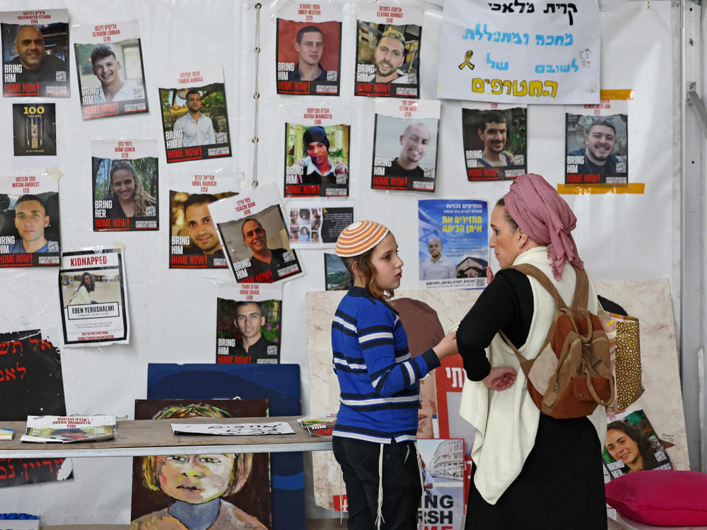 People stand in front of portraits of hostages taken by Hamas during the Oct. 7 attack on Monday, Feb. 12, outside Tel Aviv's Museum of Art, now informally called the 
