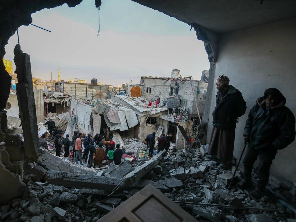 People inspect the damage to their homes on Monday, Feb. 12, following Israeli air strikes in Rafah.