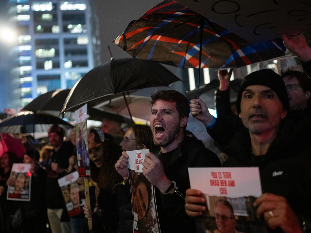 Gil Dickman, whose cousin Carmel Gat is still in captivity in Gaza, and other relatives of the hostages demonstrate outside of The Kirya, in Tel Aviv, which houses the Israeli Ministry of Defense, after handcuffing themselves to one another on Thursday, Feb. 15, during a protest calling for a deal to secure their release.