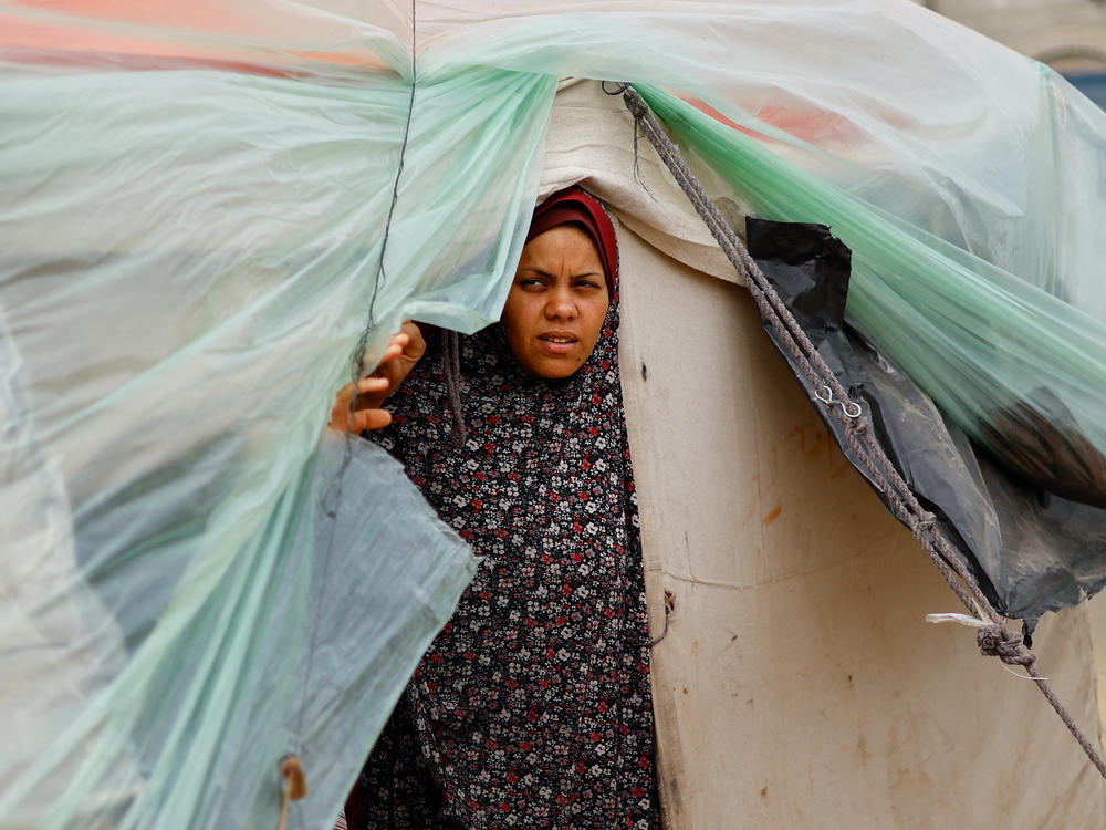 A displaced Palestinian woman who fled her house due to Israeli strikes takes shelter in a tent camp in Rafah on Tuesday, Feb. 13, amid the ongoing conflict between Israel and Hamas.