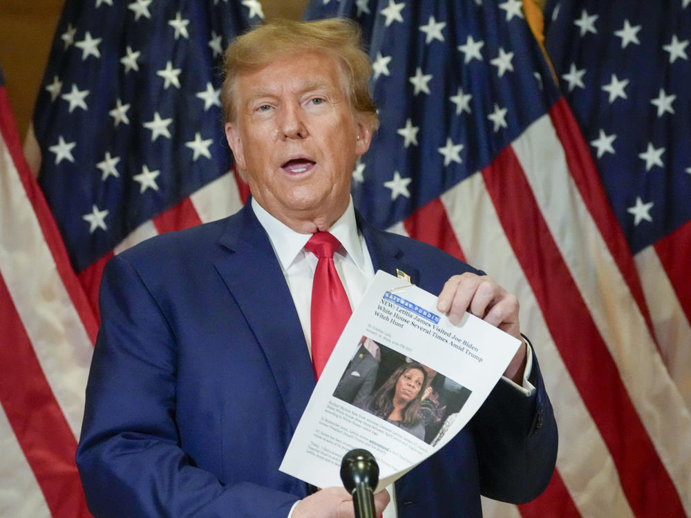 Former President Donald Trump holds up a copy of a story featuring New York Attorney General Letitia James at a news conference this January. Trump has accused James of targeting him unfairly.