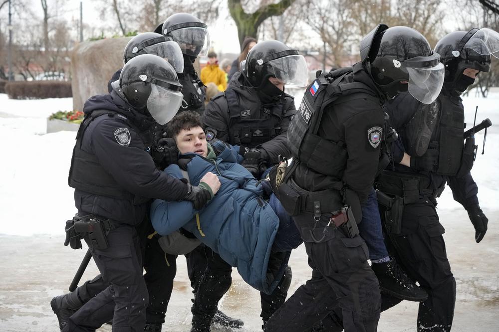 Police detain a man as he wanted to lay flowers for Alexei Navalny at a monument in St. Petersburg on Saturday.