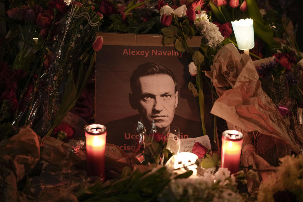 Flowers and candles are laid around a photo of Russian opposition leader Alexei Navalny in Italy.