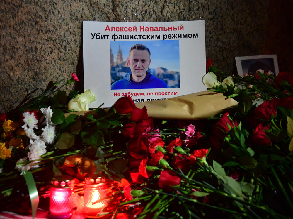 Flowers lay next to a picture of late Russian opposition leader Alexei Navalny at a makeshift memorial organized at the monument to the victims of political repressions in Saint Petersburg.