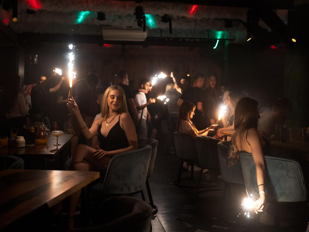 Patrons at a club in Kharkiv, in northeastern Ukraine, hold sparklers in a darkened room in May. Despite the war, people still find a way to release tension in the battered city's nightclubs.