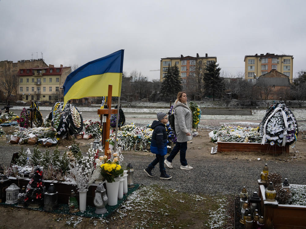Bohdan Semenukha and his mother, Viktoria, walk frequently through the Lychakiv cemetery in Lviv, Ukraine, just a few blocks from the new apartment where they moved after fleeing Kharkiv, in the country's northeast, in January 2023.