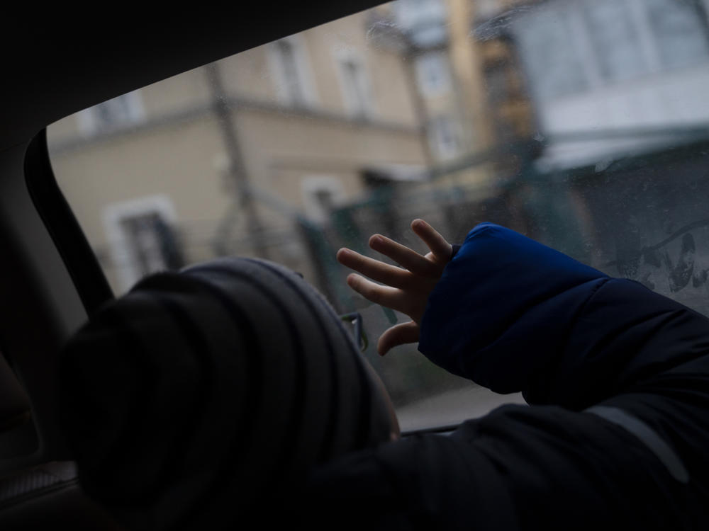 Bohdan Semenukha looks out the car window while his mom, Viktoria, drives him home from his new school in Lviv, in western Ukraine, in January 2023.