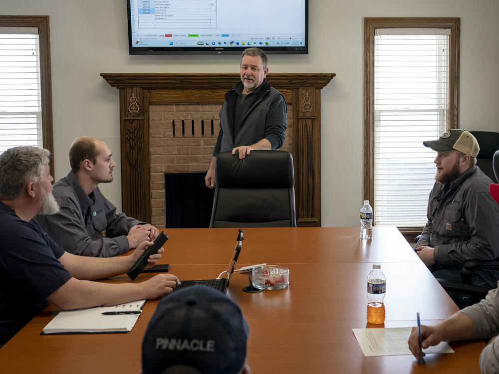 Doug Vance, middle, holds a staff meeting with technicians in February.