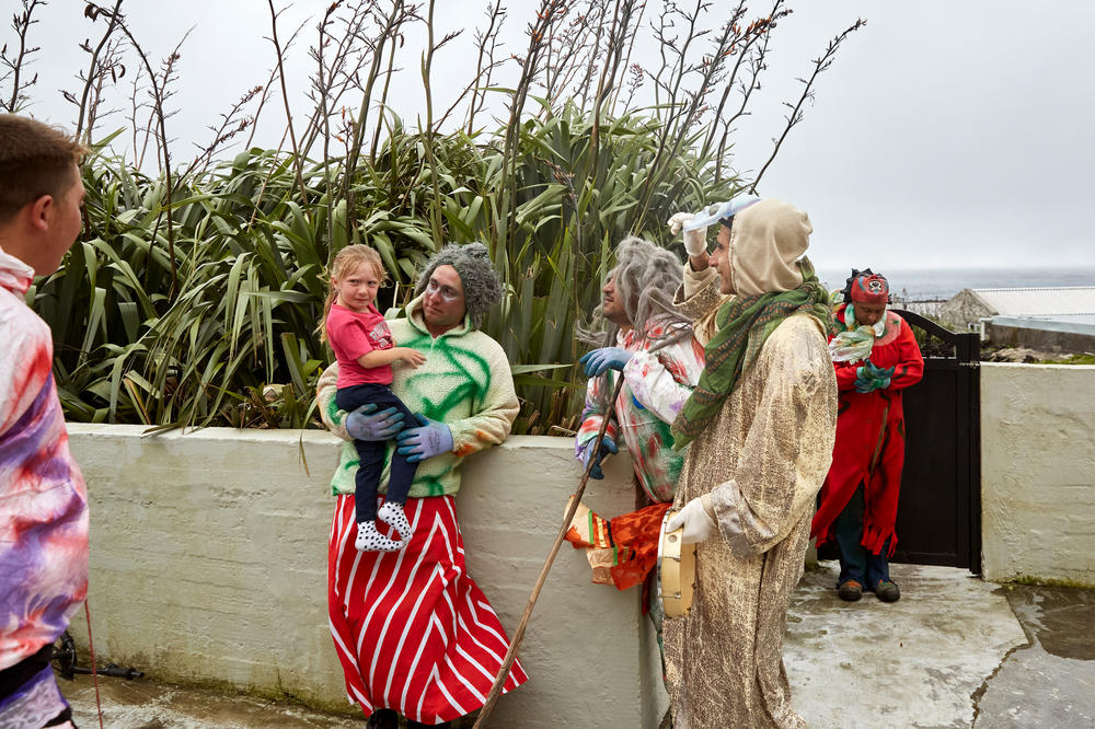 After removing his mask to reveal himself, Julian Repetto holds and comforts his daughter, Makayla. When this did not calm the little girl, the other Okalolies followed suit. The Okalolies are careful not to frighten children and the elderly too much. Some islanders, however, are genuinely afraid and will lock themselves inside their houses.