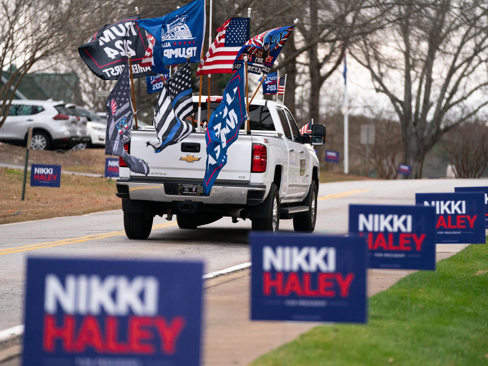 A supporter of former President Donald Trump drives past campaign signs for Republican presidential candidate Nikki Haley in Irmo, South Carolina. The state's Republican presidential primary is on Feb. 24.