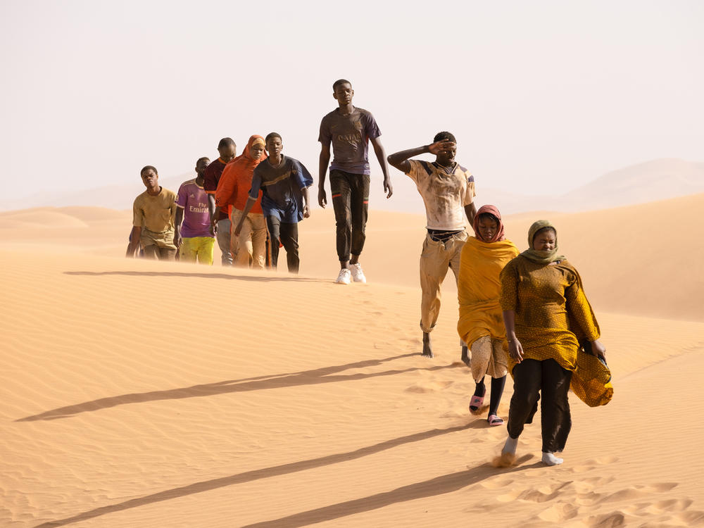 Seydou (Seydou Sarr, in gray) crosses the desert in <em>Io Capitano.</em>