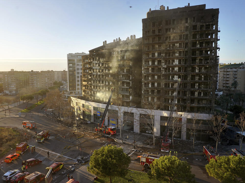 Firefighters work at a burned block building in Valencia, Spain, on Friday.