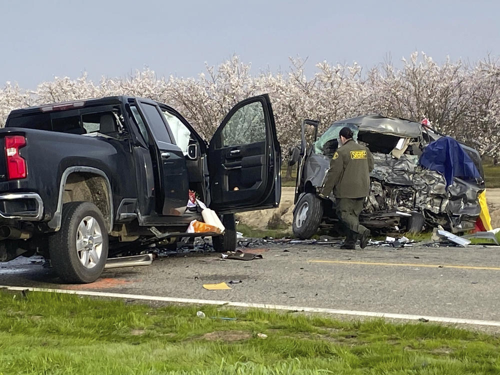 The site of a head-on crash involving a van and a pickup truck where eight people were killed is checked in Madera County, Calif., on Friday.