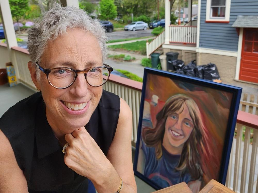 Julie Petrow-Cohen at her 61st birthday, with a painting done by her brother Jay when she was 16.